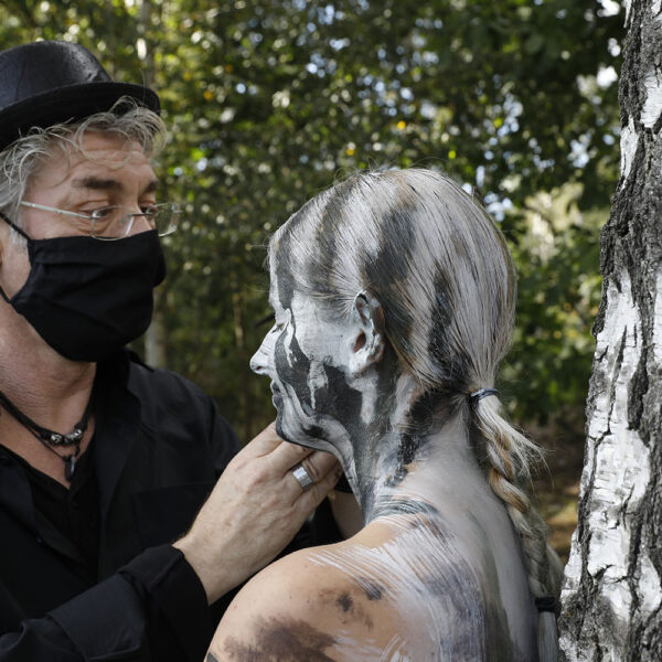 Ein nacktes Fotomodell wird für das Kunstprojekt Natureart von Künstler Jörg Düsterwald vollständig so mit Farbe bemalt, dass die Person mit der Kulisse verschmilzt.