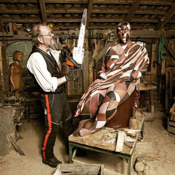 Für das Kunstprojekt WORKING ART, bei dem Berufe mit Bodypaintingmodellen dargestellt werden, hat Künstler Jörg Düsterwald ein Fotomodell vollständig bemalt. Die gestylte Frau hält sich zusammen mit einem Holzbildhauer in seiner Werkstatt auf.