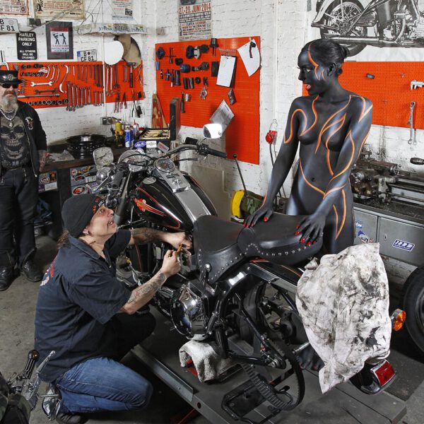 Für das Kunstprojekt WORKING ART, bei dem Berufe mit Bodypaintingmodellen dargestellt werden, hat Künstler Jörg Düsterwald ein Fotomodell vollständig bemalt. Die gestylte Frau hält sich zusammen mit einem Mechaniker in einer Motorradwerkstatt auf.